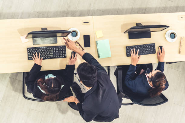istock Business people wearing headset from top view in office working with computer 1273474473