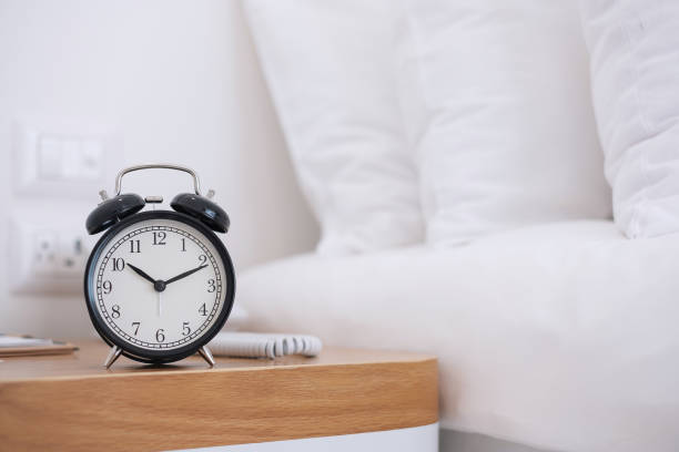 istock Black Retro alarm clock on table in bedroom at night, sleeping and daily routine concept 1273475556