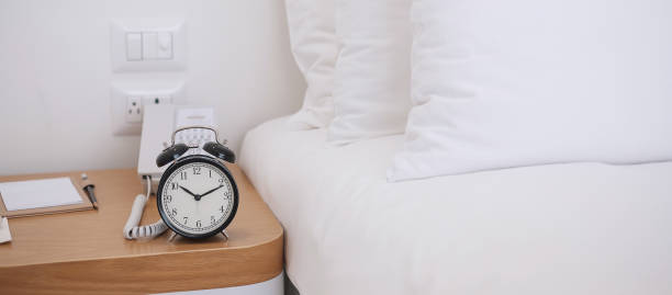 istock Black Retro alarm clock on table in bedroom at night, sleeping and daily routine concept 1273475563