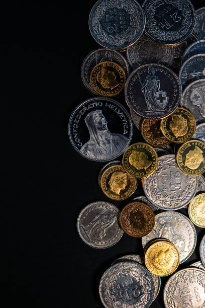 istock Swiss franc coins lie on a dark background. 1273475746