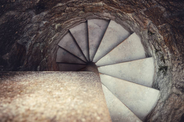 top wiew of an ancient stone spiral staircase, really narrow to climb with stone walls