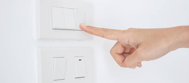 istock Closeup Male finger is turn on or off on light switch on white wall at home. Energy Saving, power, electrical and lifestyle concepts 1273476608