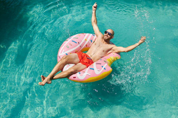 istock A trained middle-aged man is lying on an inflatable donut with red swimming trunks and sunglasses in the pool, enjoying his vacation. 1273477819