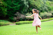 芝生の上で裸足で遊ぶ女の子