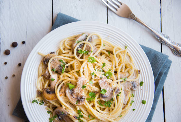 istock Spaghetti pasta with mushrooms, creamy sause and parsley on white 1273478884