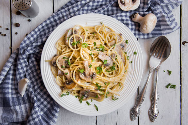 istock Spaghetti pasta with mushrooms, creamy sause and parsley on white 1273478955