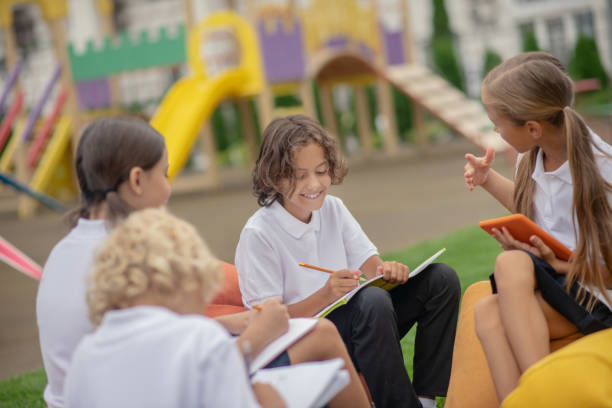 istock Group of pupils sitting outside and preparing homework 1273478987