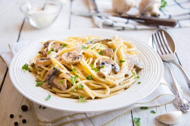 istock Spaghetti pasta with mushrooms, creamy sause and parsley on white 1273479160