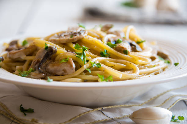 istock Spaghetti pasta with mushrooms, creamy sause and parsley on white 1273479295