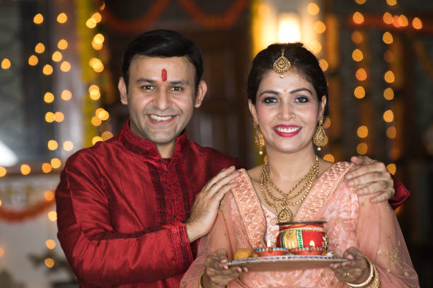 Happy Indian couple with a plate of religious offering on the occasion of festival celebration