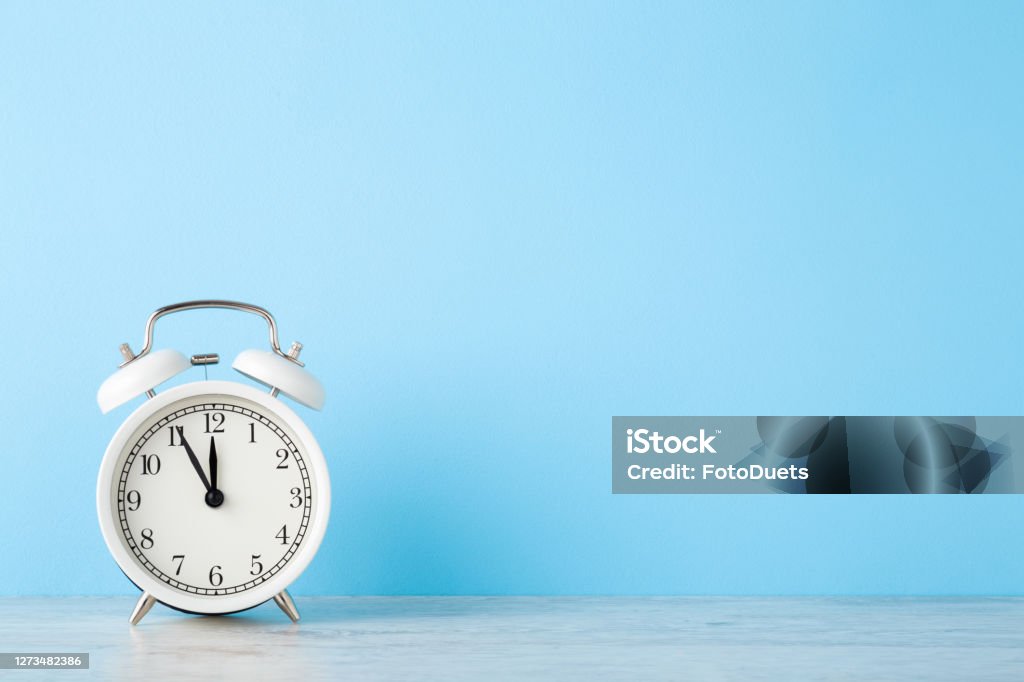 White Alarm Clock On Wooden Table At Light Blue Wall Background Pastel Color Time Concept Closeup Empty Place For Text Front Stock Photo - Download - iStock
