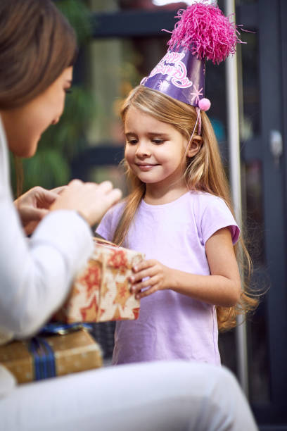 little caucasian girl receiving birthday from young adult female little caucasian girl receiving birthday from young adult female brunette happy birthday cousin images stock pictures, royalty-free photos & images