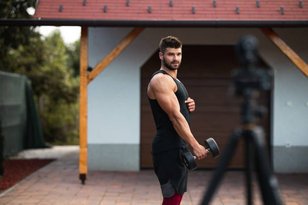 istock Male athlete doing exercise in backyard and filming vlog. 1273484688