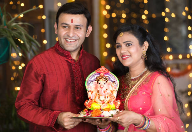 Indian couple carrying statue of Hindu god Ganesh Happy Indian couple carrying statue of Hindu god Ganesh on the occasion of festival celebration Ganesh Chaturthi stock pictures, royalty-free photos & images
