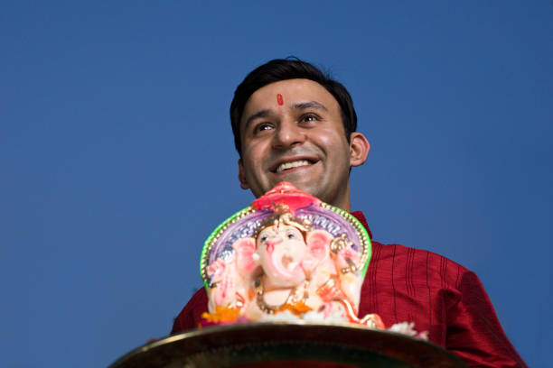 Happy man carrying statue of Hindu god Ganesh on the occasion of Ganesh Chaturthi festival