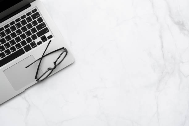 istock White marble office desk table with laptop computer and eye glasses. Top view with copy space, flat lay. 1273486172