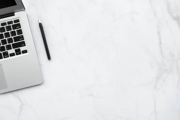istock White minimal marble office desk table with laptop computer and pen. Top view with copy space, flat lay. 1273486194