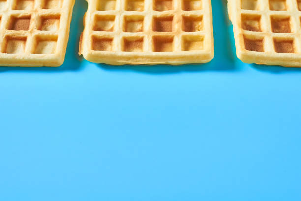 istock Row of vanilla belgian waffles on blue background 1273486972
