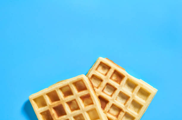istock Two vanilla belgian waffles on blue background 1273486974