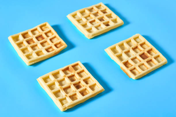 istock Four vanilla belgian waffles on blue background 1273486984