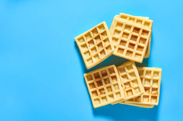 istock Stack of vanilla belgian waffles on blue background. Top view 1273487002