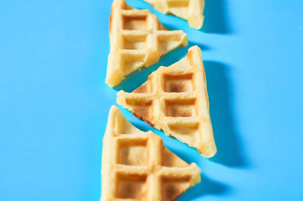 istock Row of cutted vanilla belgian waffles on blue background 1273487011