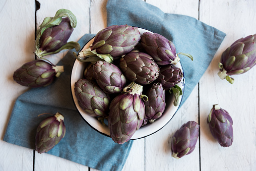 Fresh uncooked artichokes vegetables on darck background, healthy food concept