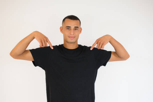 istock Young sporty man against a white background points down with fingers, positive feeling 1273489898
