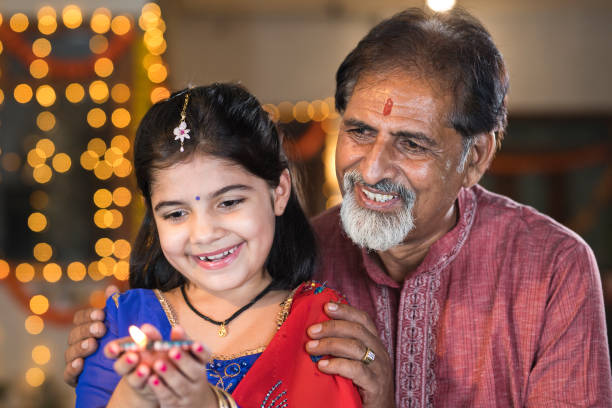 großvater und enkelin feiern anlässlich des diwali-festivals - indian culture family senior adult asian ethnicity stock-fotos und bilder