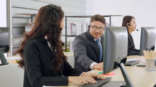 istock Business people wearing headset working in office 1273492341