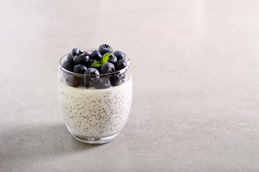 Chia seed pudding with blueberry topping, served in glass
