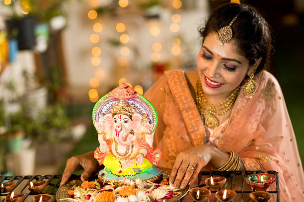 Beautiful woman with Diya and statue of lord Ganesha Beautiful Indian woman with diya oil lamps and statue of Hindu god Ganesha on the occasion of festival celebration ganesh chaturthi photos stock pictures, royalty-free photos & images