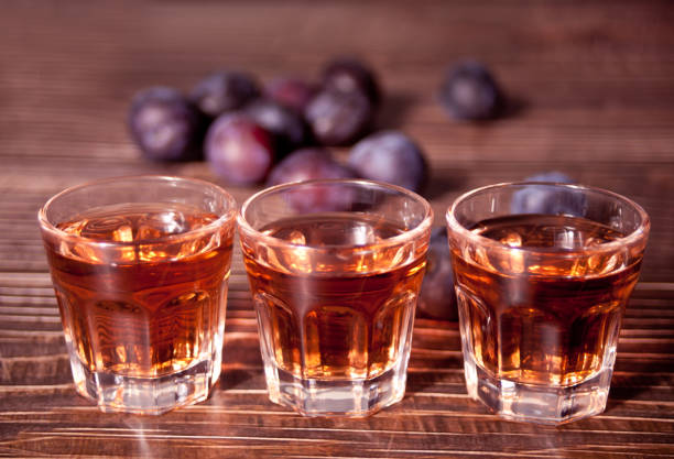 木製のテーブルの上に新鮮な梅と梅ウォッカやブランデー。 - plum fruit brandy ストックフォトと画像