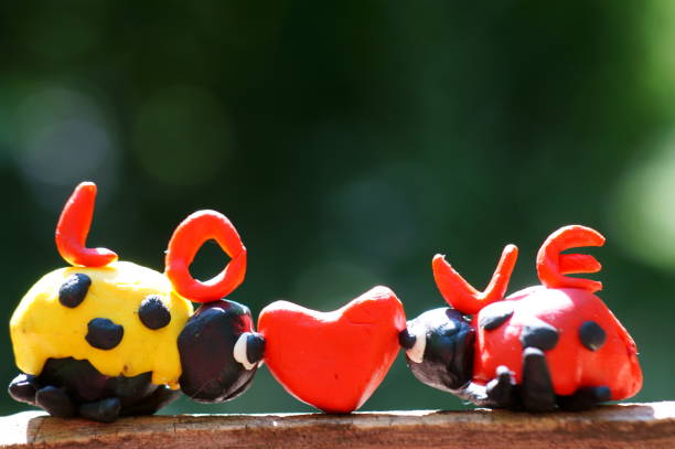 istock Figures of two ladybirds on a wooden surface. 1273507503