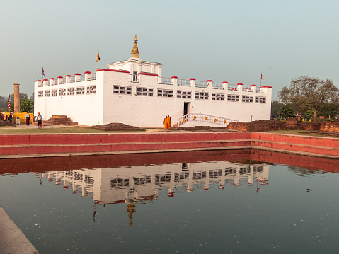 Lumbini, Nepal - March 2015: The ancient Maya Devi temple in Lumbini, the birthplace of the Buddha, reflected in the waters of a pond.