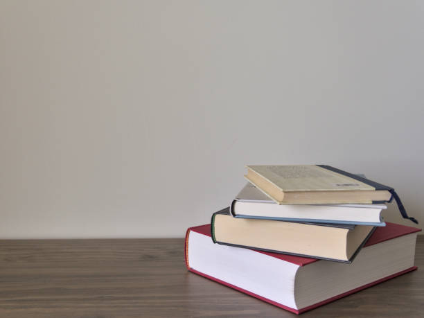 istock Stack of books on a table with light colored background.Education learning and reading concept 1273509839