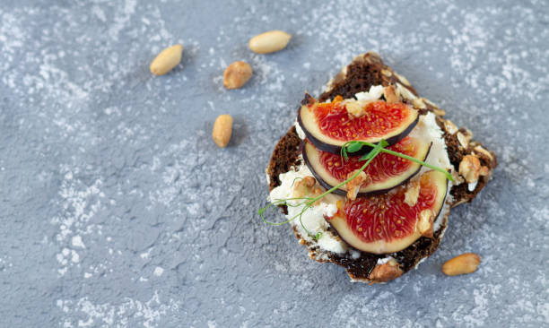 istock Mini bruschetta (open sandwich or toast) with fig, cheese, honey and nuts top view 1273509952