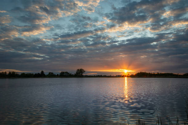 istock Beautiful sunset with clouds over the lake 1273510191
