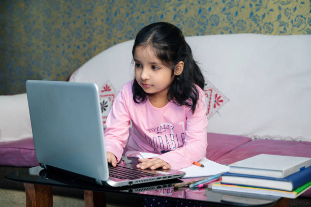 istock Child girl using laptop, Online classes at home on Laptop. 1273510382