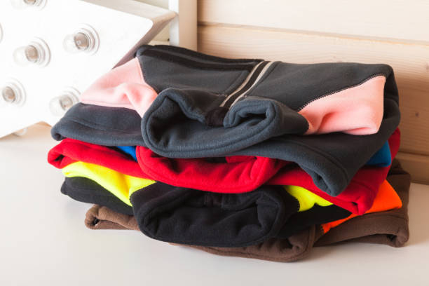 istock Colorful fleece jackets lay stacked on a white table 1273511167