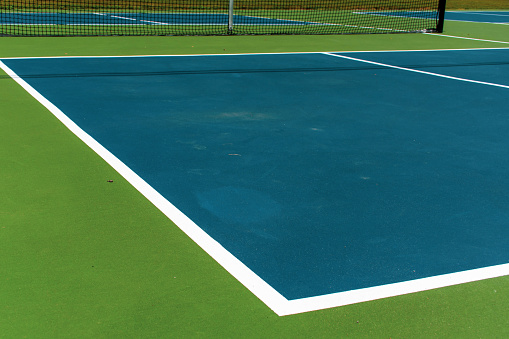 Recreational sport of pickleball court in Michigan, USA looking at an empty blue and green new court at a outdoor park. Ground View.