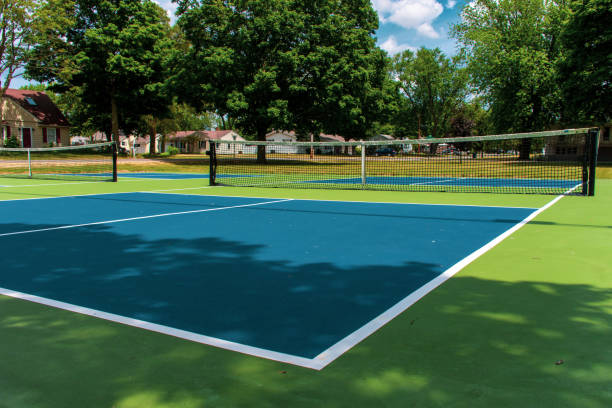 deporte recreativo de la cancha de pickleball en michigan, ee. uu. mirando una nueva cancha azul y verde vacía en un parque al aire libre. vista al suelo. - tennis court tennis net indoors fotografías e imágenes de stock