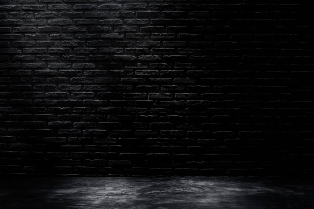 istock Dark room with black brick wall with concrete floor and lighting effect. 1273514394