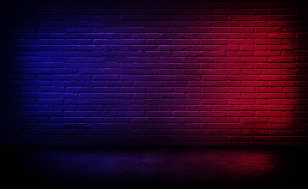 istock Studio dark room black brick wall with red and blue lighting effect. 1273515510