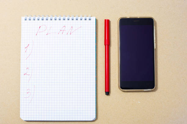 notepad, red marker and phone, top view