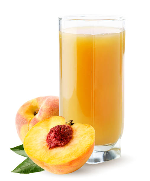 istock Juice is poured into a glass with a peach on a white background. Isolated 1273516558