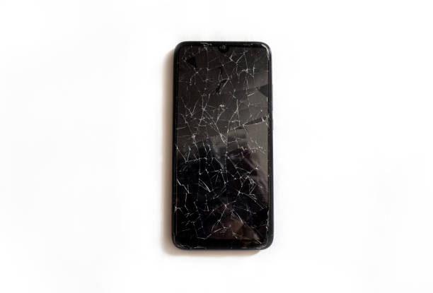 istock A modern mobile black touch smartphone with a broken glass screen isolated on a white background. Service, repair and technological concept. Copy space for text. 1273516684