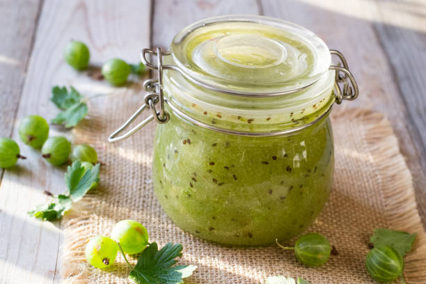 Gooseberry jam in jar on wooden table Gooseberry jam in jar on wooden table gooseberry stock pictures, royalty-free photos & images