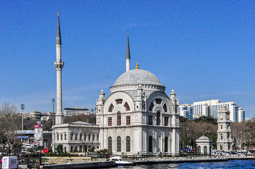 View from a boat floating on the Strait of Bosphorus of the Dolmabahce Mosque located in the Besiktas district at Istanbul city, Turkey.