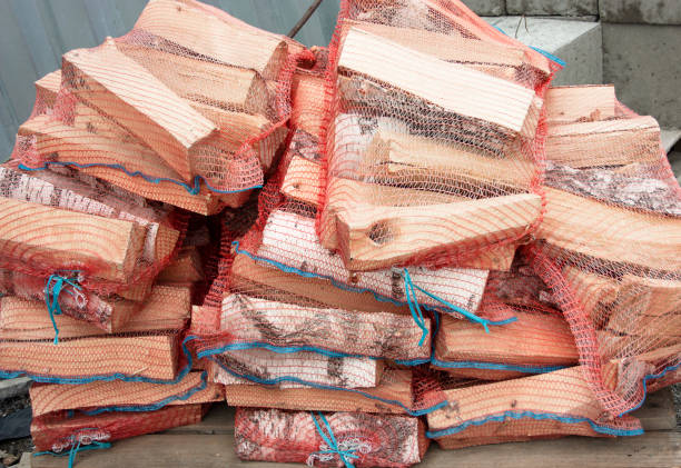 stos drewna opałowego brzozowego zapakowany w sieć na sprzedaż - wood cutting chopping fireplace zdjęcia i obrazy z banku zdjęć